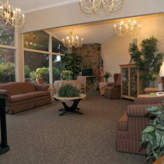 A cozy lobby with comfortable seating, chandeliers, and large windows.