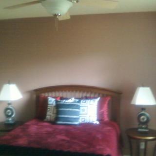 Cozy bedroom with a double bed, two bedside lamps, and a ceiling fan.