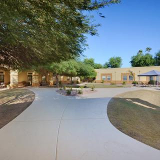 A serene outdoor relaxation area with a winding pathway and benches on a sunny day.