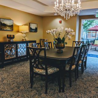 Elegant dining room with a chandelier and a large table set for guests.