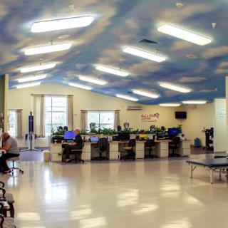 An open workspace with computers and a sky-themed ceiling.