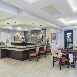 Modern kitchen and dining area with stylish lighting and seating arrangements.