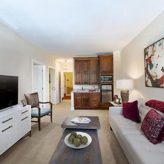 A cozy living room with modern decor, featuring a comfortable sofa, a television, and stylish artwork on the wall.