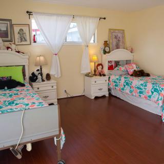 A cozy bedroom with two twin beds, decorated in a playful and colorful style.