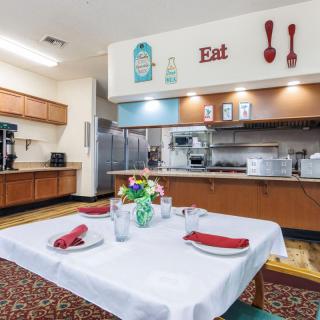 A cozy kitchen and dining area with a neatly set table, featuring colorful decor and kitchenware.