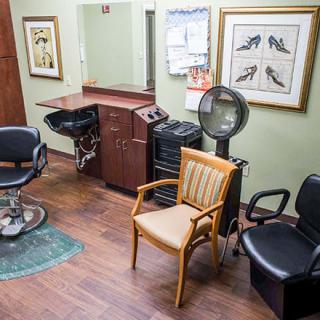 A cozy barbershop interior with various chairs and salon equipment.