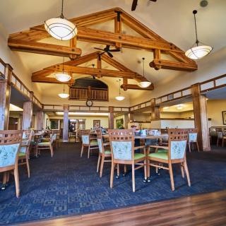 Spacious dining area with wooden beams and elegant chandeliers.