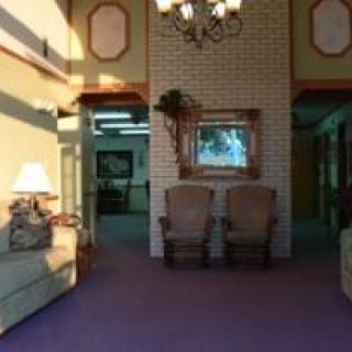 A cozy lobby area with seating, a mirror, and a chandelier.