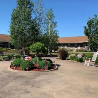 A serene courtyard garden with benches and lush greenery surrounded by buildings.