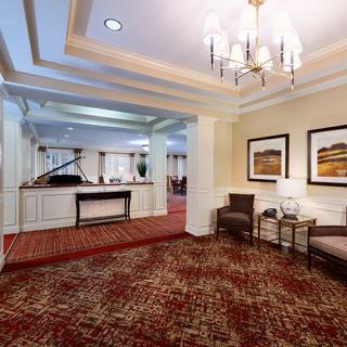 A spacious lobby with elegant dcor, featuring a chandelier and comfortable seating.