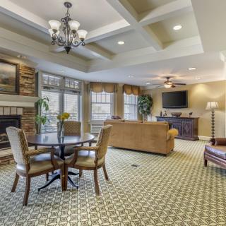 Cozy living room with elegant decor, featuring a fireplace, comfortable seating, and a large television.
