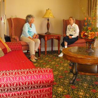 Two people having a conversation in a cozy living room setting.