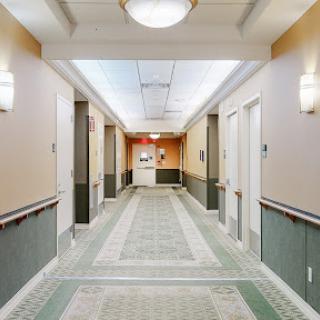 A view of a well-lit hotel hallway leading to the reception area.