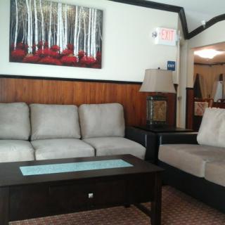A cozy living room with sofas, a coffee table, and artwork on the wall.