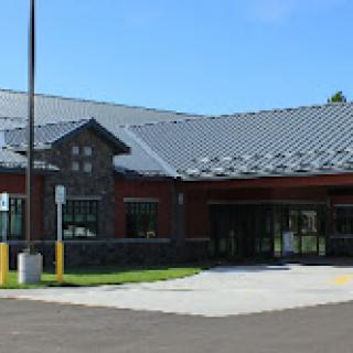 A modern commercial building with a sleek design and prominent stone accents.