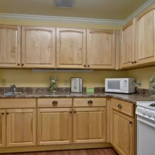 A cozy kitchen featuring light wooden cabinets and modern appliances.