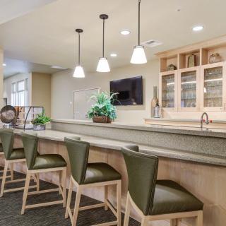 A modern home bar with a sleek countertop and stylish stools.