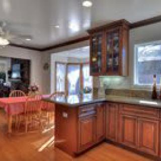 A warm and inviting kitchen with wooden cabinetry and an adjacent dining area.