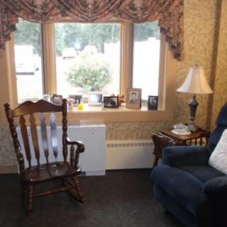 A cozy living room corner with a rocking chair and armchair by the window.