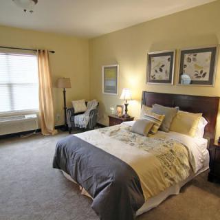 A cozy bedroom with a neatly made bed and warm lighting.