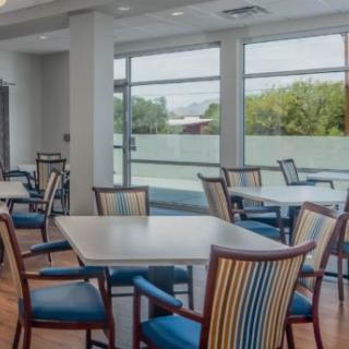 Bright dining area with tables and chairs near large windows.