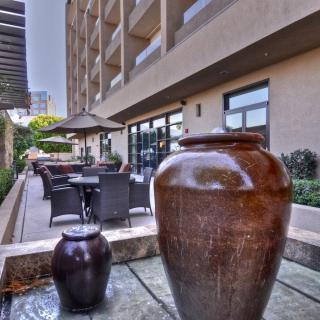 A spacious outdoor patio area with large decorative pots and seating arrangements near a building exterior.