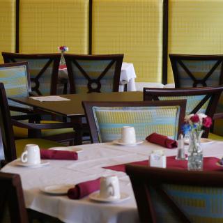 A neatly set dining area with tables and chairs arranged in a restaurant.