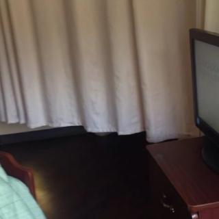 A cozy room with a television and curtains.