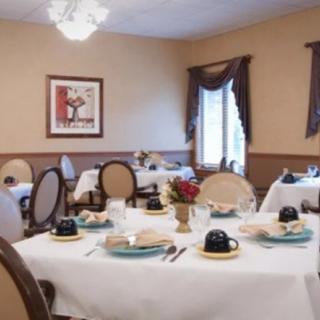 A well-arranged dining room with elegantly set tables, featuring neatly placed tableware and comfortable chairs.