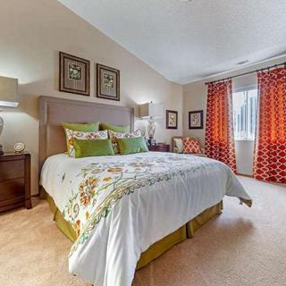 A cozy bedroom with a large bed, vibrant curtains, and elegant decor.