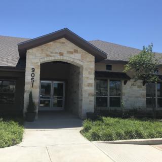 A modern office building with a stone facade and well-maintained landscaping.