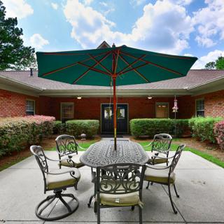 A tranquil courtyard featuring a patio set with an umbrella, enclosed by a brick building.