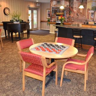 A cozy lounge area with a checkers set on the table and comfortable seating, adjacent to a counter.