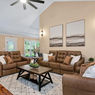 A cozy living room featuring comfortable sofas, a central coffee table, and elegant wall art.