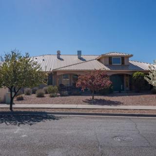 A suburban house with a landscaped front yard under a clear blue sky.
