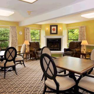 A cozy living room with tables, chairs, and a fireplace.