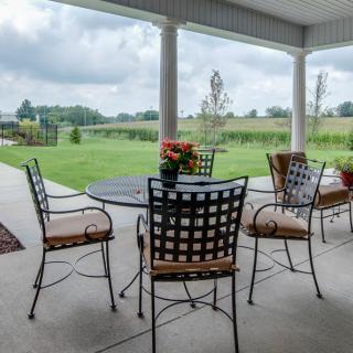 A tranquil patio with outdoor seating overlooking a lush green landscape.