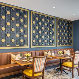 Art Deco-inspired restaurant interior with booth seating and decorative wall art.