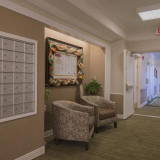 A cozy hallway with chairs, mailboxes, and decorative elements.