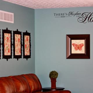 A cozy living room featuring a red leather sofa, decorative wall art, and a comforting quote.