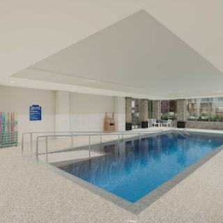 A serene indoor swimming pool, featuring a modern design and inviting clear water.