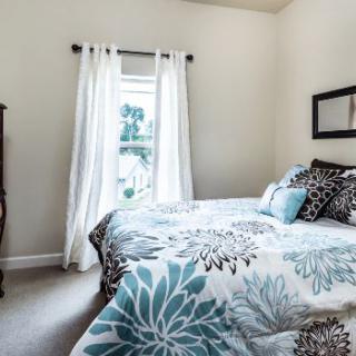 A cozy bedroom with floral bedding and natural light.