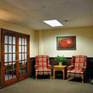 A cozy waiting room with plaid chairs and a small wooden table.