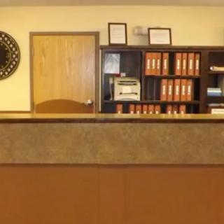 An office reception area with a desk and shelves filled with binders.
