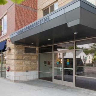 A modern building entrance with glass doors and a covered awning.