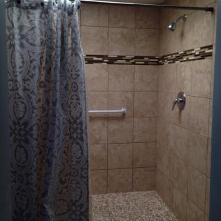 A modern tiled shower area with a decorative curtain.