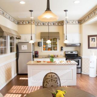 A bright and cozy modern kitchen with stainless steel appliances and pendant lighting.