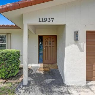 A welcoming front entrance of a house with a wooden door and white walls.