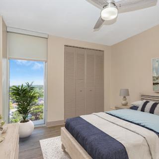 A modern and stylish bedroom featuring natural light, contemporary decor, and a scenic window view.