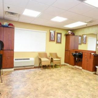 A well-lit waiting area with chairs, a sink, and a large mirror.